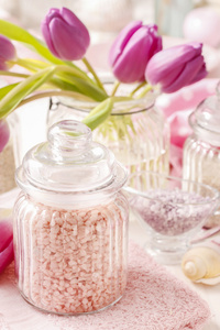 玻璃罐里的粉红色海盐白色木制的桌子上