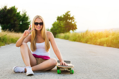 有吸引力微笑时髦少女与滑板，与 sunflare 的图像