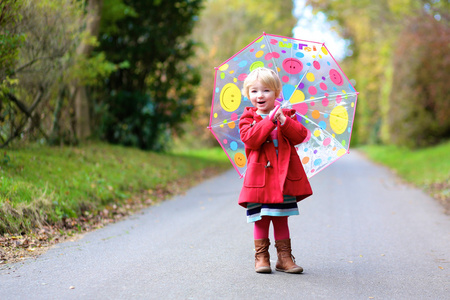 带着彩色雨伞的顽皮小女孩的肖像