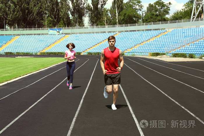 年轻人在体育场上慢跑照片-正版商用图片1jnmy9-摄图新视界