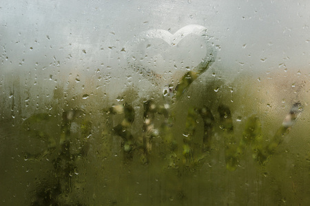 雨水落在汗流满面的玻璃上。悲伤的悲伤阴郁的秋天