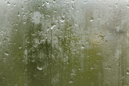 雨水落在汗流满面的玻璃上。悲伤的悲伤阴郁的秋天