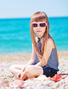 太阳镜在海滩上的小女孩