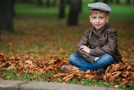 小滑稽的男孩在秋天树叶肖像