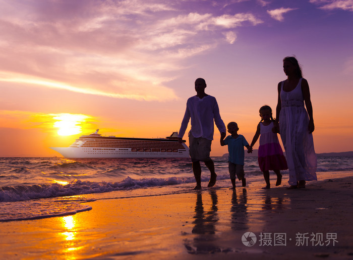 家人在海滩日落概念行走