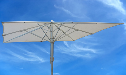白色的沙滩伞概念在蓝蓝的天空