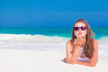 在热带巴巴多斯海滩吹空气吻上比基尼长发女孩