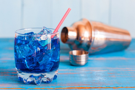 清凉爽快蓝柑鸡尾酒在 pounchy 玻璃与多维数据集的冰和振动筛上木制的背景