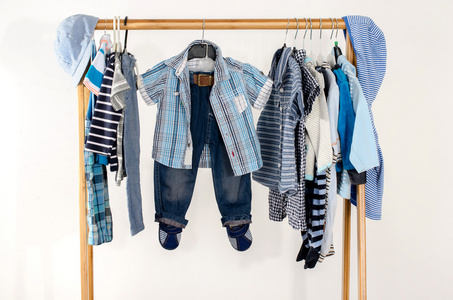 更衣室衣柜与安排在衣架上的衣服。蓝色和白色衣柜的新生儿，孩子，幼儿，婴儿充满了所有的衣服。很多 t 恤，裤子，衬衫，衬衫，蓝色的