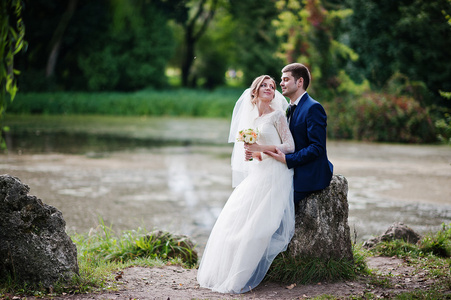 两人在两个石头和湖附近的公园里的婚礼