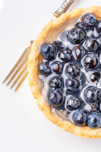 新鲜的蓝莓自制蛋挞放在木桌子上