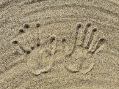 两只手印在沙滩上