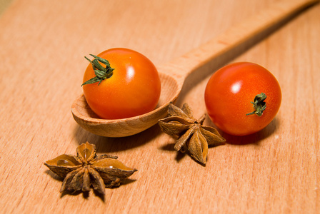 红番茄在木质表面上的勺子和星茴香