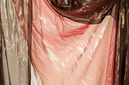 粉红色棕色透明织物。 纹理。 长袍。 在摄影棚里拍照
