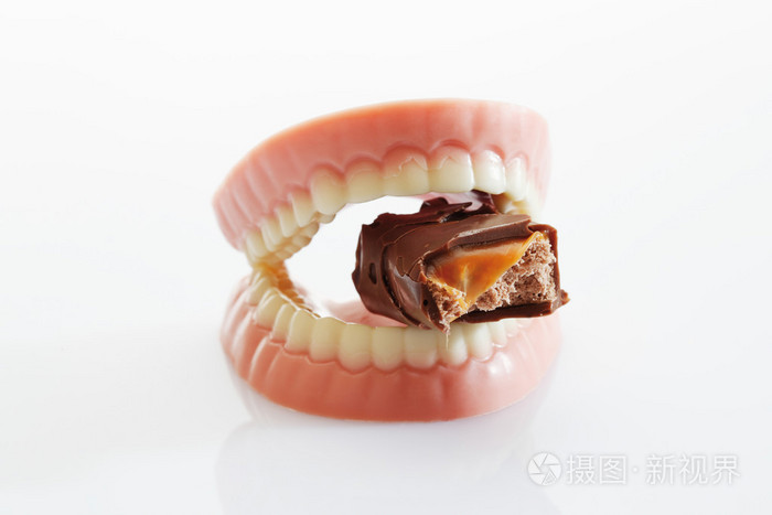 由糖和白巧克力咬巧克力棒的假牙