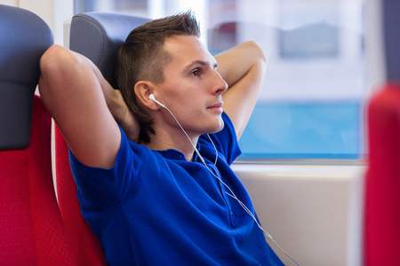 快乐的年轻人乘火车旅行的听音乐