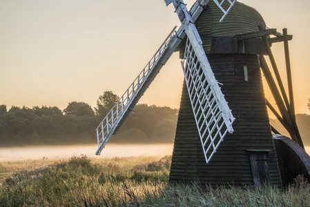 古老的风车在英格兰雾农村景观