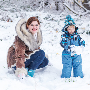 学龄前的小男孩和他的母亲玩在 p 中的第一场雪
