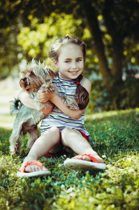 快乐的小女孩和狗在草地上玩