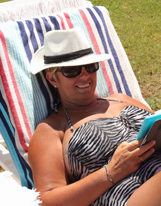 一个在度假时戴着帽子和太阳镜的成熟女人