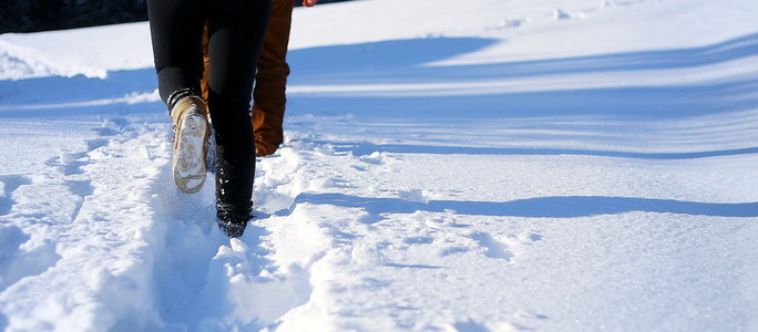 在山上的雪地上散步。雪地上的脚印复制空间