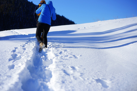 在山上的雪地上散步。雪地上的脚印