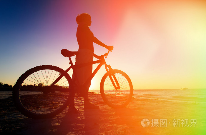 骑自行车在日落时分的女人