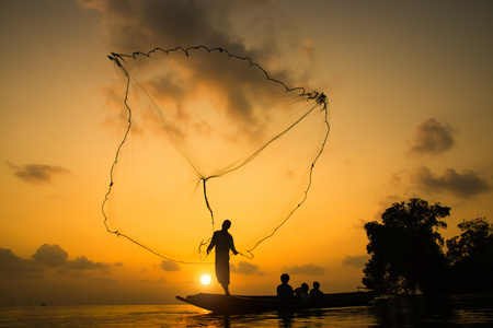 日落，泰尔期间抛渔网的剪影渔夫