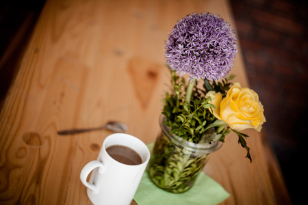 杯咖啡和木制背景上美丽的鲜花