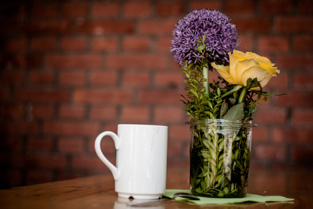 杯咖啡和木制背景上美丽的鲜花