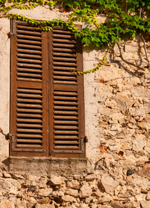 老窗口与百叶窗在老石头墙壁图片