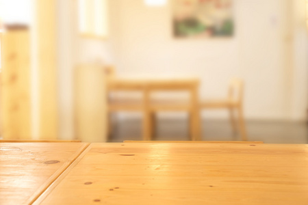 抽象模糊明亮的餐厅内部与木制桌子在焦点