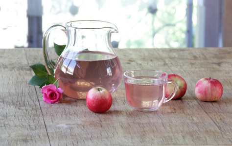 在一个透明的苹果蜜饯水罐新鲜的苹果和一朵玫瑰