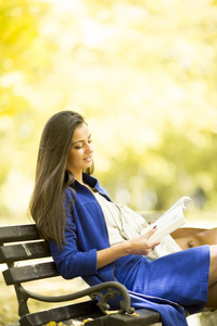 读一本书在公园里的年轻女子