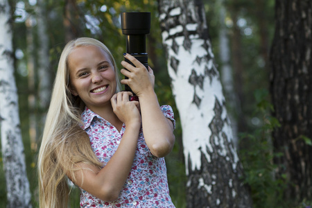 在森林里的年轻女孩摄影师