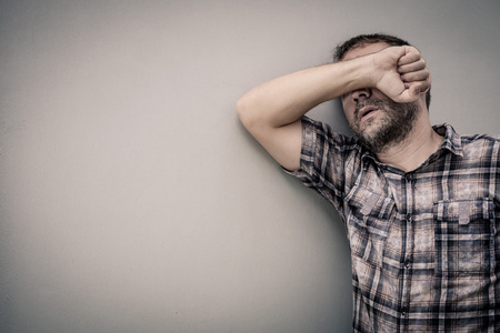 肖像伤心人站附近的一堵墙,遮住了脸照片