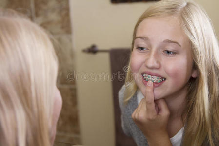 女孩照镜子，检查她的牙套