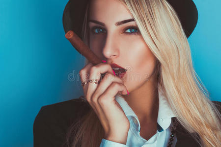 迷人的金发女人抽着雪茄照片