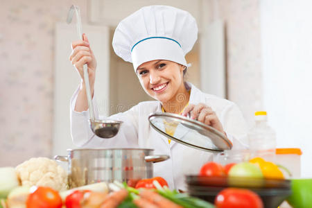 锅瓢快乐美丽的厨师用勺子工作照片