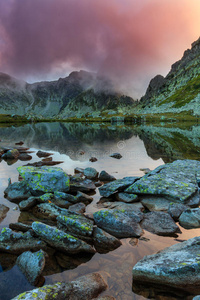 阿尔卑斯山原始的冰川湖和日落时的暴风云