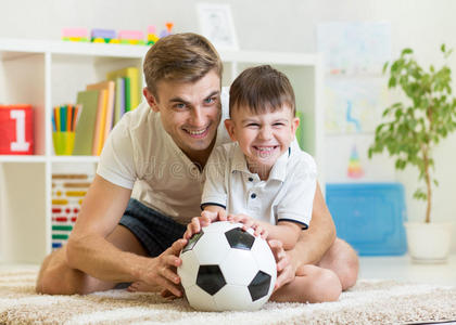 小男孩和爸爸在室内玩足球