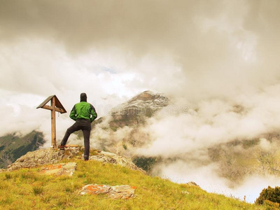 游客站在岩石景观点上，观看雾蒙蒙的阿尔卑斯山谷。