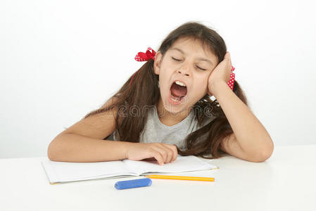 累了的孩子累了的孩子在做作业时打哈欠照片