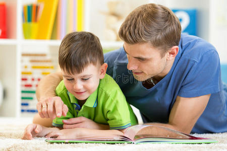 孩子和父亲在家里的地板上看书