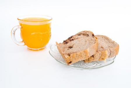 白色盘子上的面包和一杯橙汁。 在白色上隔离。