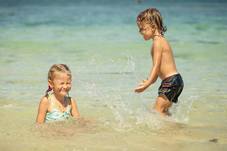 三个快乐的孩子在沙滩上玩耍