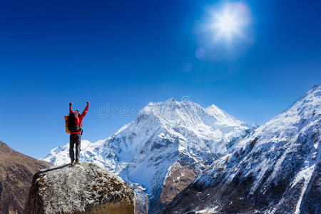 徒步旅行者在徒步到达山顶后，高举双臂，欢呼雀跃