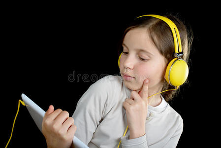 一个年轻漂亮的女孩在用数字平板电脑听音乐