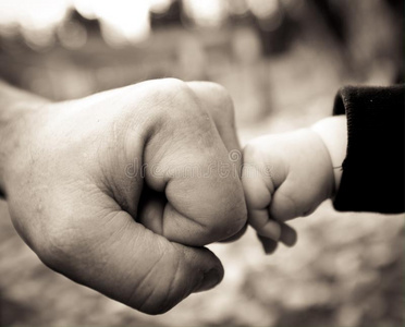 爸爸和宝宝的拳头碰撞和孩子的拳头碰撞拳头突破白墙男子攥紧的拳头攥