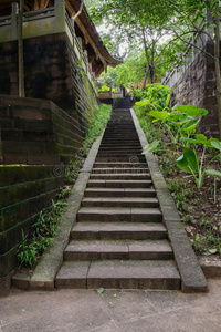 阴暗的石阶通往山坡上的中国古建筑